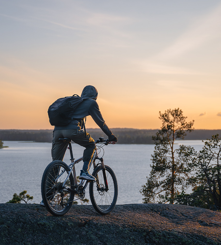 An image depicting a cyclist in a peaceful archipelago, symbolizing the company's values.