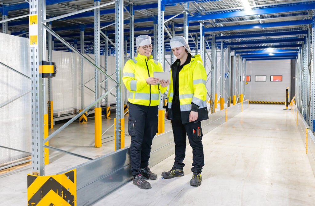 Smiling staff coordinating and cooperating in warehouse
