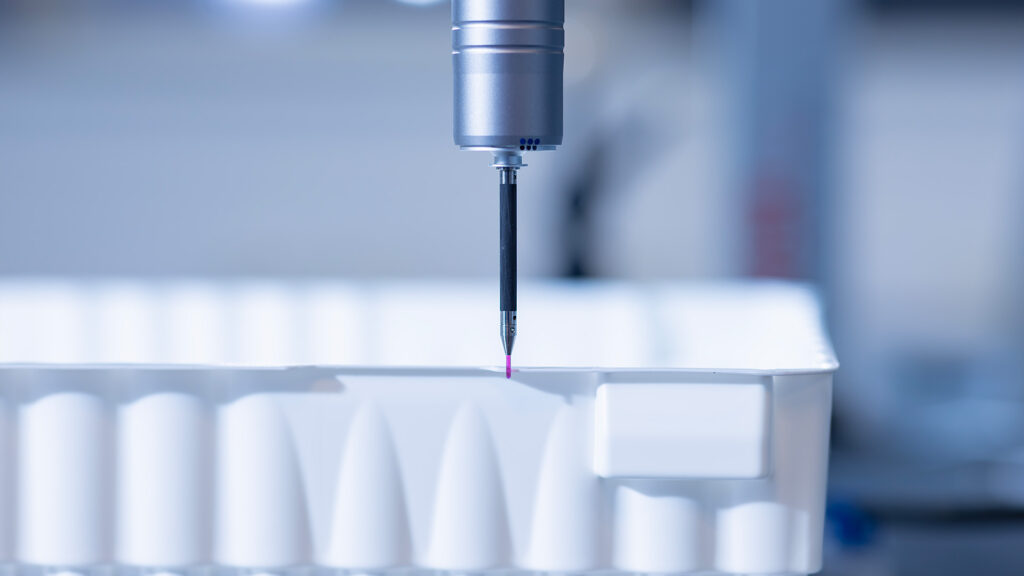 Close-up of a packaging product under inspection with precision measuring equipment.