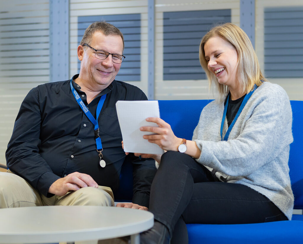 Two employees examining project documents collaboratively.