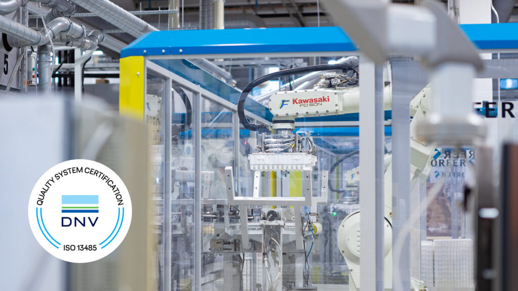 Automated robot moving plastic packaging, ISO 13485 logo displayed