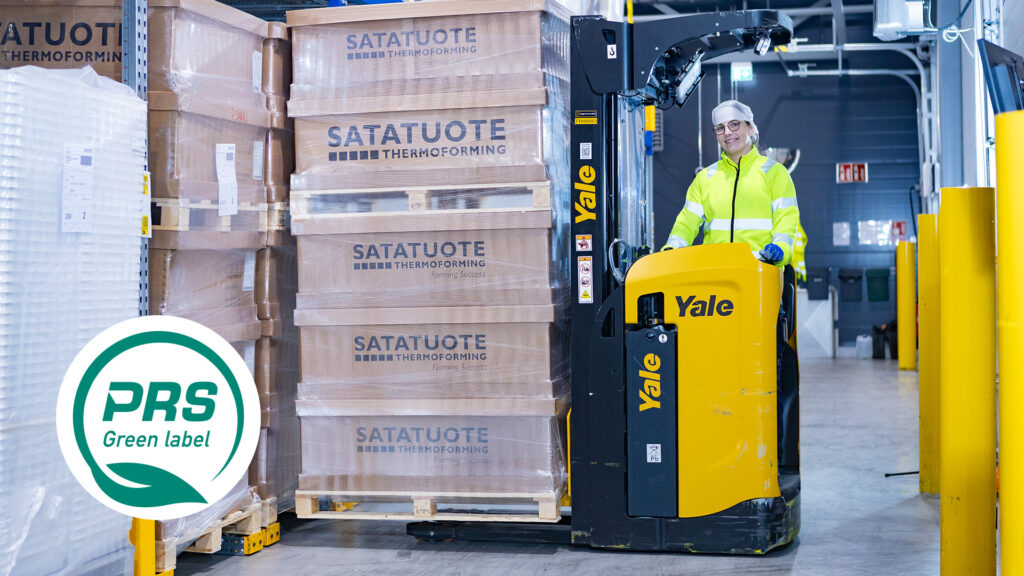 Smiling staff member operating forklift with packages